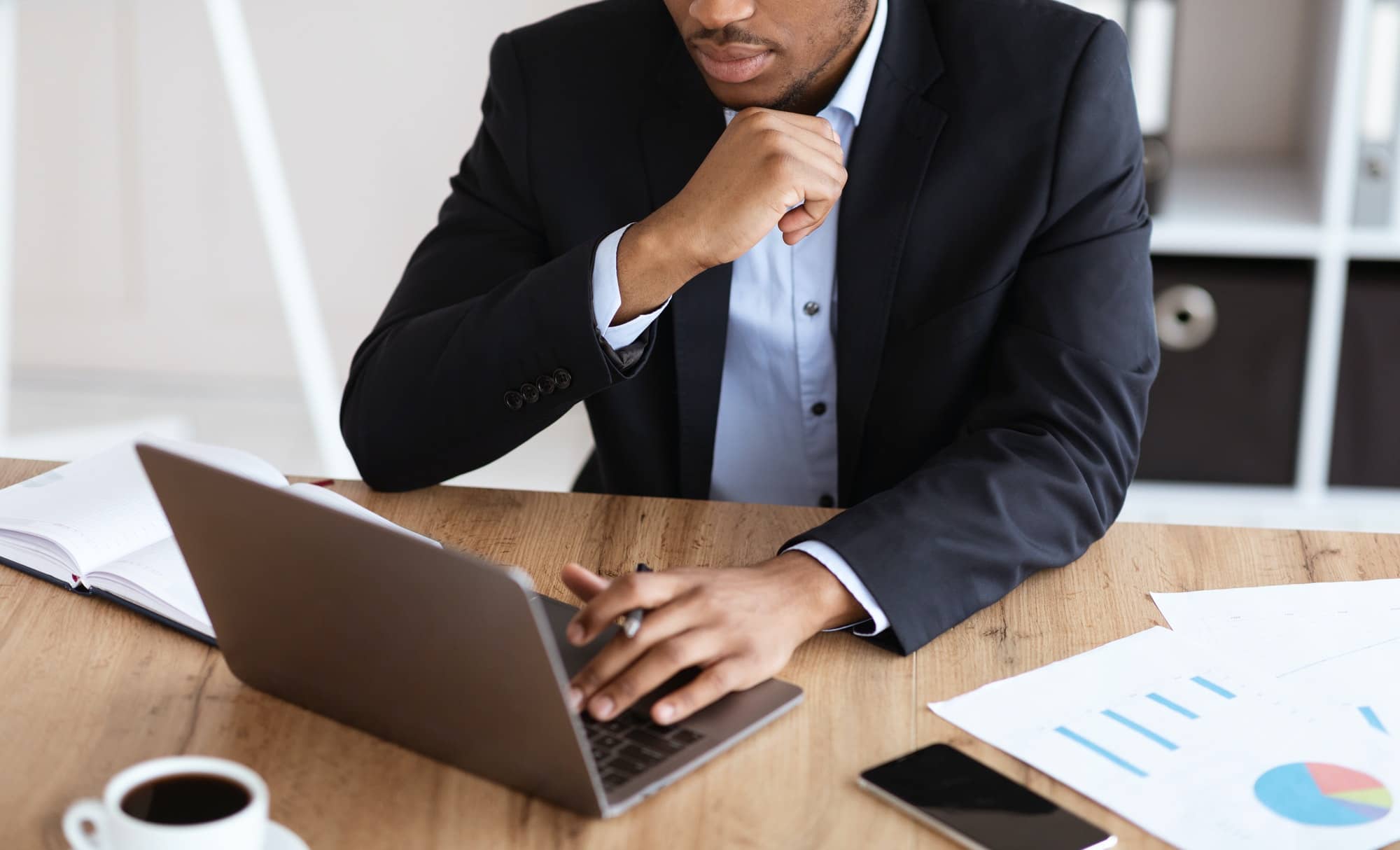 Cropped of black manager working with laptop, reading marketing report